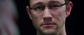 Movie still from “Snowden” (2016), directed by Oliver Stone – A person wearing glasses; Close Up shot, Over the shoulder angle