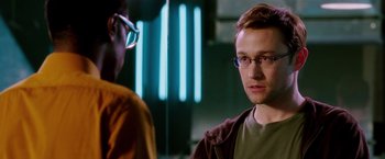 Movie still from “Snowden” (2016), directed by Oliver Stone – A young man wearing glasses is talking to another young man; Close Up shot, Over the shoulder angle