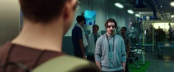 Movie still from “Snowden” (2016), directed by Oliver Stone – A group of men standing around in a room; Medium shot, Over the shoulder angle