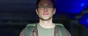 Movie still from “Snowden” (2016), directed by Oliver Stone – A person wearing glasses and a jacket; Close Up shot, Low angle