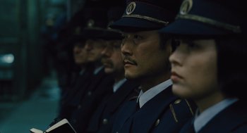 Movie still from “Snowpiercer” (2013), directed by Bong Joon Ho – A group of people in uniform are lined up; Close Up shot, Low angle