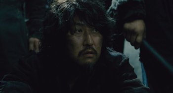 Movie still from “Snowpiercer” (2013), directed by Bong Joon Ho – A person wearing a black shirt; Close Up shot, Low angle