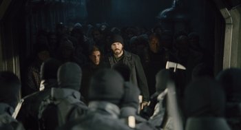 Movie still from “Snowpiercer” (2013), directed by Bong Joon Ho – A group of people standing around in a room; Medium shot, Over the shoulder angle