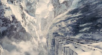 Movie still from “Snowpiercer” (2013), directed by Bong Joon Ho – A train traveling on tracks through a snow covered mountain range; Extreme Wide shot, Overhead angle