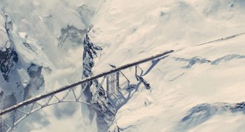 Movie still from “Snowpiercer” (2013), directed by Bong Joon Ho – An aerial view of a ski lift in the middle of a snow covered slope; Extreme Wide shot, Overhead angle