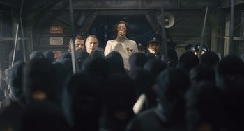 Movie still from “Snowpiercer” (2013), directed by Bong Joon Ho – A group of people standing on top of a train; Medium shot, Low angle