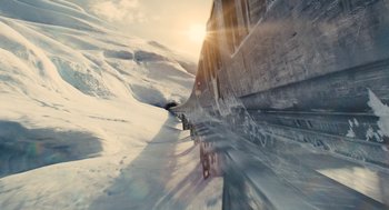 Movie still from “Snowpiercer” (2013), directed by Bong Joon Ho – A train traveling down tracks through a snow covered landscape; Extreme Wide shot, Low angle