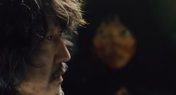 Movie still from “Snowpiercer” (2013), directed by Bong Joon Ho – A person's face in a dark room; Close Up shot, Over the shoulder angle