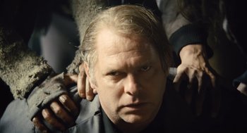 Movie still from “Snowpiercer” (2013), directed by Bong Joon Ho – A person getting his hair combed back; Close Up shot, Over the shoulder angle