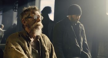 Movie still from “Snowpiercer” (2013), directed by Bong Joon Ho – A man with a beard and glasses sitting next to another man with a beard; Medium shot, Over the shoulder angle