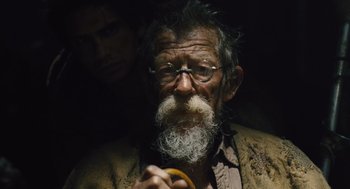 Movie still from “Snowpiercer” (2013), directed by Bong Joon Ho – An old man with a long beard holding an orange; Close Up shot, Over the shoulder angle