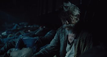 Movie still from “Snowpiercer” (2013), directed by Bong Joon Ho – An old man sitting in a dark room with a beard; Close Up shot, Over the shoulder angle