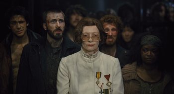 Movie still from “Snowpiercer” (2013), directed by Bong Joon Ho – A group of people standing in a room; Medium shot, Low angle