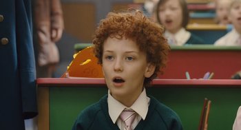 Movie still from “Snowpiercer” (2013), directed by Bong Joon Ho – A boy with curly red hair wearing a green sweater; Close Up shot, Low angle