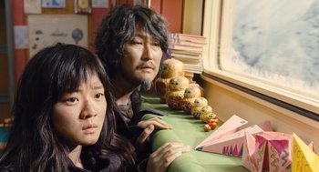 Movie still from “Snowpiercer” (2013), directed by Bong Joon Ho – A man and a woman sitting next to each other in front of a window; Close Up shot, Low angle