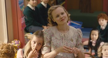 Movie still from “Snowpiercer” (2013), directed by Bong Joon Ho – Two young girls sitting next to each other in a room; Medium shot, Over the shoulder angle