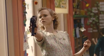 Movie still from “Snowpiercer” (2013), directed by Bong Joon Ho – A woman holding a gun in a room; Medium shot, Low angle
