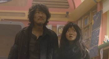Movie still from “Snowpiercer” (2013), directed by Bong Joon Ho – A man and a woman standing next to each other; Medium shot, Low angle