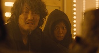 Movie still from “Snowpiercer” (2013), directed by Bong Joon Ho – A man and a woman are looking at the camera; Close Up shot, Low angle