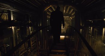 Movie still from “Snowpiercer” (2013), directed by Bong Joon Ho – A man walking down a set of stairs in the dark; Wide shot, Low angle