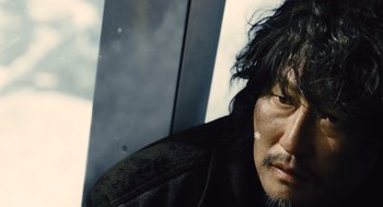 Movie still from “Snowpiercer” (2013), directed by Bong Joon Ho – A person wearing a black jacket; Close Up shot, Low angle