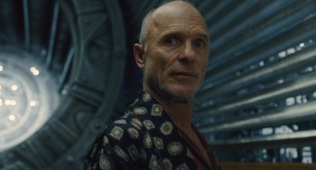 Movie still from “Snowpiercer” (2013), directed by Bong Joon Ho – A man with a shaved head wearing a black and white shirt; Close Up shot, Low angle