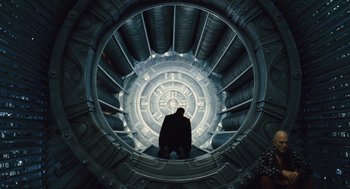 Movie still from “Snowpiercer” (2013), directed by Bong Joon Ho – A man standing inside of an airplane engine; Wide shot, Low angle