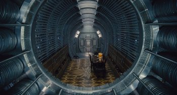Movie still from “Snowpiercer” (2013), directed by Bong Joon Ho – A room that has a table and chairs inside of it; Wide shot, Overhead angle