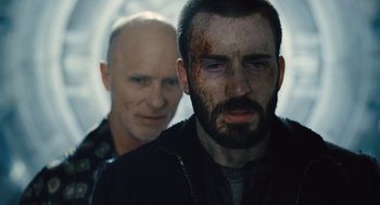Movie still from “Snowpiercer” (2013), directed by Bong Joon Ho – A man with a shaved head and a bearded man with a shaved head; Close Up shot, Over the shoulder angle