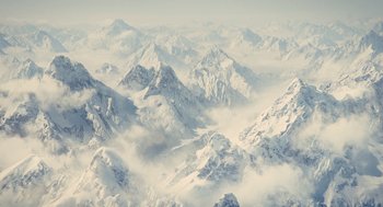 Movie still from “Snowpiercer” (2013), directed by Bong Joon Ho – A view of a mountain range from a plane window; Extreme Wide shot, High angle