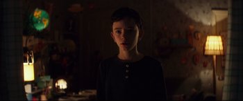 Movie still from “A Monster Calls” (2016), directed by J.A. Bayona – A young boy standing in a dark room; Close Up shot, Over the shoulder angle
