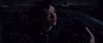 Movie still from “A Monster Calls” (2016), directed by J.A. Bayona – A young boy sitting on top of a couch looking up; Close Up shot, High angle