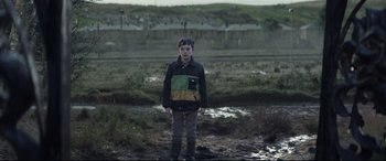 Movie still from “A Monster Calls” (2016), directed by J.A. Bayona – A young boy standing in a muddy field; Wide shot, Over the shoulder angle