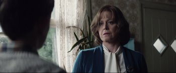 Movie still from “A Monster Calls” (2016), directed by J.A. Bayona – An older woman in a white shirt and blue jacket; Close Up shot, Over the shoulder angle