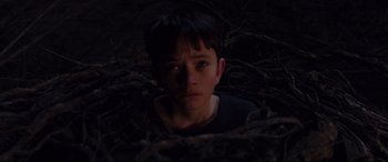 Movie still from “A Monster Calls” (2016), directed by J.A. Bayona – A young boy in the dark looking at the camera; Close Up shot, High angle