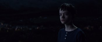 Movie still from “A Monster Calls” (2016), directed by J.A. Bayona – A young boy standing in the dark looking at the camera; Close Up shot, High angle