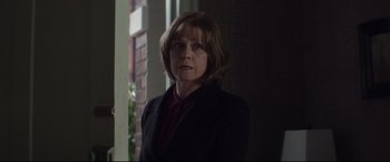 Movie still from “A Monster Calls” (2016), directed by J.A. Bayona – A woman in a black jacket is standing in front of a window; Close Up shot, Over the shoulder angle