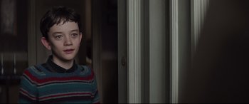 Movie still from “A Monster Calls” (2016), directed by J.A. Bayona – A young boy standing in front of an open door; Close Up shot, Over the shoulder angle