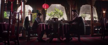 Movie still from “A Monster Calls” (2016), directed by J.A. Bayona – Two people sitting at a table in front of a lamp; Wide shot, High angle