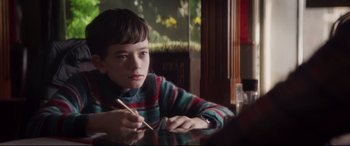 Movie still from “A Monster Calls” (2016), directed by J.A. Bayona – A boy sitting at a table with chopsticks in front of him; Close Up shot, Over the shoulder angle