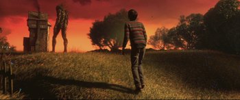Movie still from “A Monster Calls” (2016), directed by J.A. Bayona – A boy is standing in the grass at sunset; Wide shot, Low angle