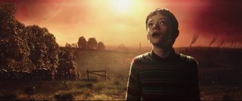Movie still from “A Monster Calls” (2016), directed by J.A. Bayona – A young boy standing in the middle of an open field; Medium shot, Low angle
