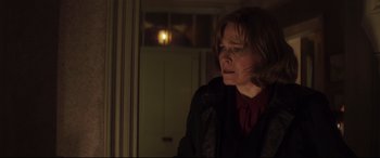 Movie still from “A Monster Calls” (2016), directed by J.A. Bayona – A woman standing in front of a window at night; Medium shot, Over the shoulder angle