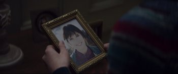 Movie still from “A Monster Calls” (2016), directed by J.A. Bayona – A person holding up a picture of a woman; Extreme Close Up shot, High angle