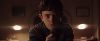 Movie still from “A Monster Calls” (2016), directed by J.A. Bayona – A young boy holding a tie in his mouth; Close Up shot, Low angle