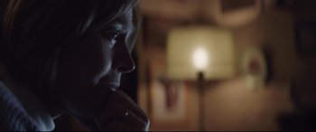 Movie still from “A Monster Calls” (2016), directed by J.A. Bayona – A woman sitting in front of a lamp in a room; Close Up shot, Over the shoulder angle