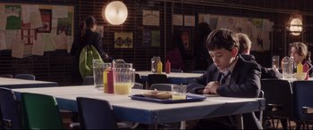Movie still from “A Monster Calls” (2016), directed by J.A. Bayona – A man sitting at a table in front of a plate of food; Medium shot, High angle