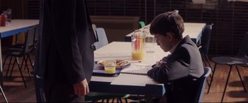 Movie still from “A Monster Calls” (2016), directed by J.A. Bayona – A boy sitting at a table with a glass of orange juice; Medium shot, Over the shoulder angle