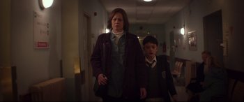 Movie still from “A Monster Calls” (2016), directed by J.A. Bayona – A woman and a boy walking down a hall way; Medium shot, Low angle
