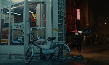 Movie still from “So Long, Stooge” (1983), directed by Claude Berri – A bicycle parked on the side of the street; Wide shot, High angle